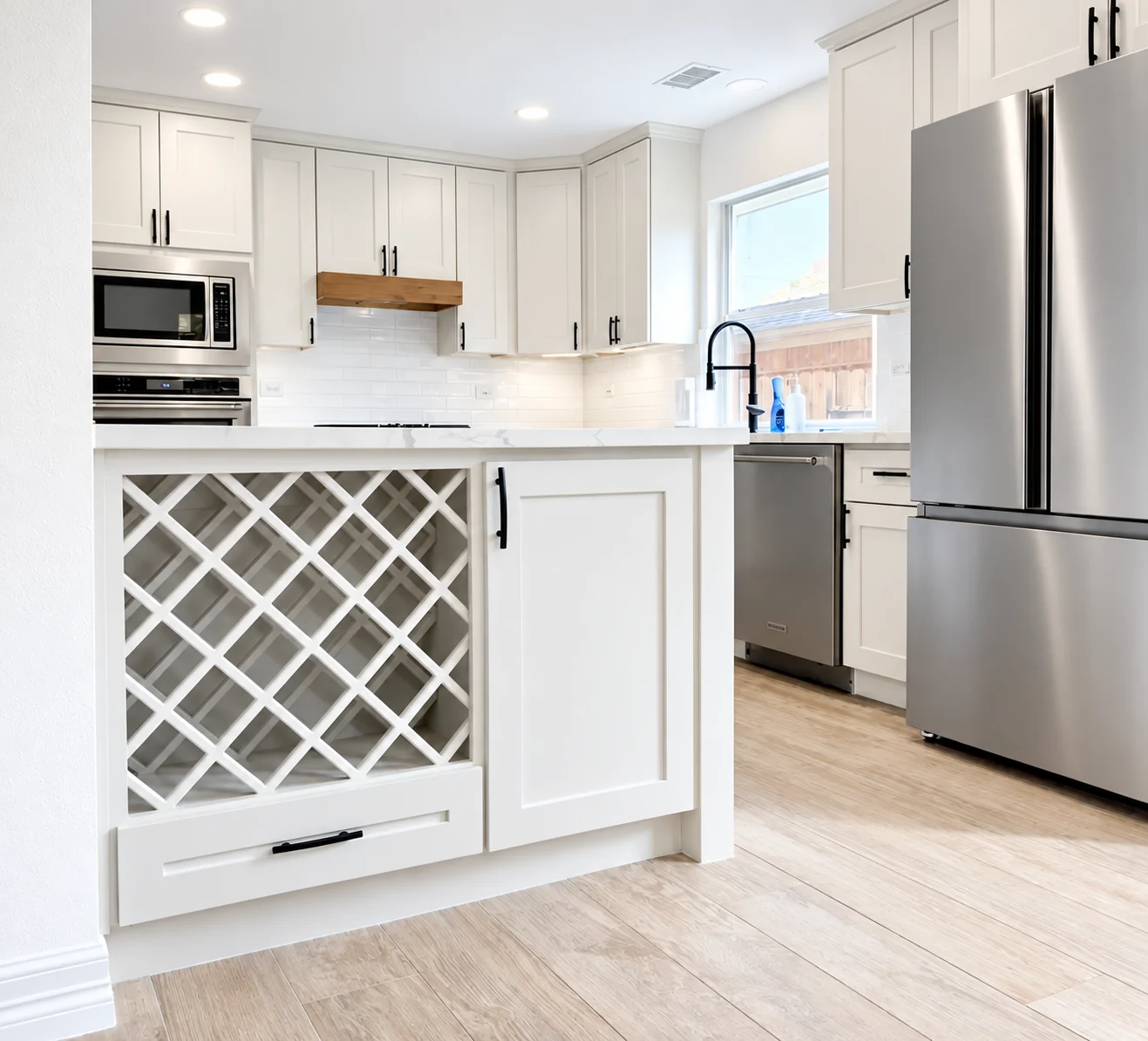 Finished kitchen with white cabinetry, island storage and stainless appliances
